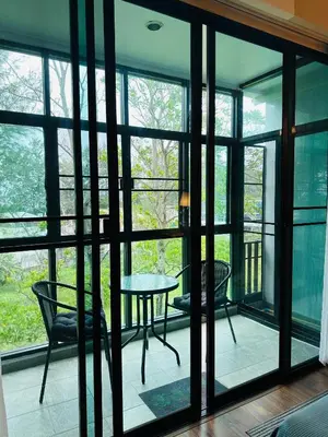 a room with glass doors and a table and chairs at Brand Naithon Condo C411 in Nai Thon Beach