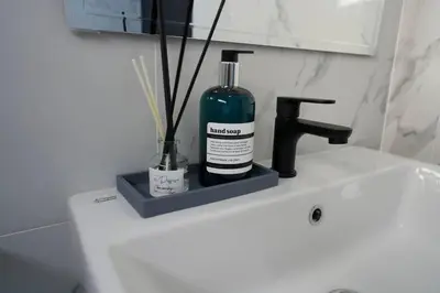 a bottle of alcohol sitting on top of a bathroom sink at House 148 Patong Pool Villa 4BR Near Beach in Patong Beach