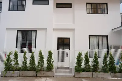 a white house with a white fence and trees at House 148 Patong Pool Villa 4BR Near Beach in Patong Beach
