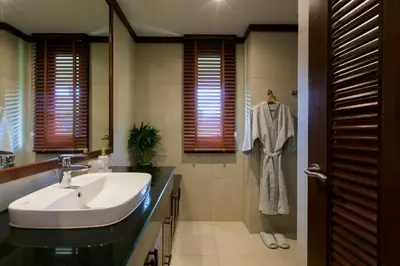 a bathroom with a sink and a robe hanging in a shower at Katamanda 1Bedrooms Apartment near Kata Beach in Kata Beach