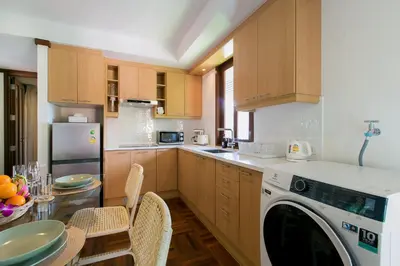 a kitchen with a dishwasher and a table with chairs at Katamanda 1Bedrooms Apartment near Kata Beach in Kata Beach