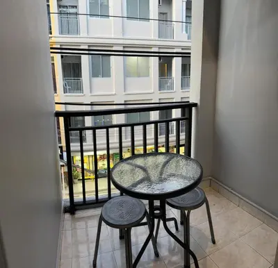 a balcony with a table and two stools at S a f e Residence Patong in Patong Beach