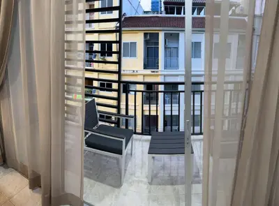 a balcony with two chairs and a view of a building at S a f e Residence Patong in Patong Beach