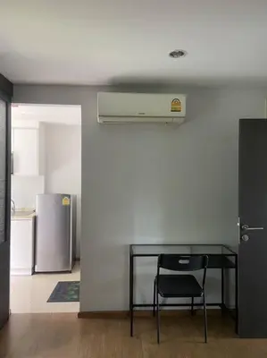 a table and a chair in a room with a refrigerator at Apartment near Central phuket in Phuket Town