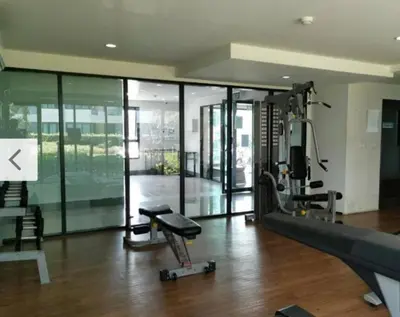 a room with a gym with a treadmill and a simulator at Apartment near Central phuket in Phuket Town
