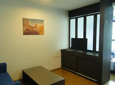 a living room with a couch and a tv in a room at Apartment near Central phuket in Phuket Town