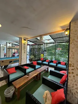 a living room with couches and tables and windows at Blueskyhouse Patong in Patong Beach