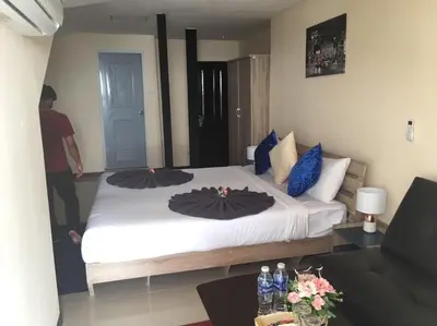 a bedroom with a large white bed with blue pillows at Blueskyhouse Patong in Patong Beach