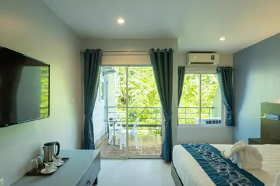a bedroom with a bed and a view of a balcony at The Great @Patong Hotel in Patong Beach