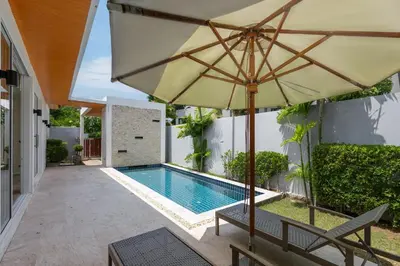an umbrella and a swimming pool in a yard at Villa Maya 2BR private pool villa Nai Harn beach in Rawai Beach