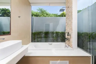 a bathroom with a white tub and a window at Villa Maya 2BR private pool villa Nai Harn beach in Rawai Beach