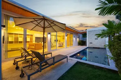 a patio with two chairs and an umbrella at Villa Maya 2BR private pool villa Nai Harn beach in Rawai Beach