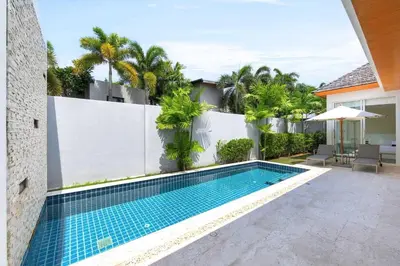 a swimming pool in a backyard with a white fence and palm trees at Villa Maya 2BR private pool villa Nai Harn beach in Rawai Beach