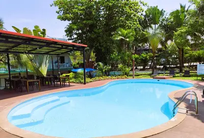 a large swimming pool with a table and chairs at Touch Sea Boutique Hotel&Bistro in Karon Beach
