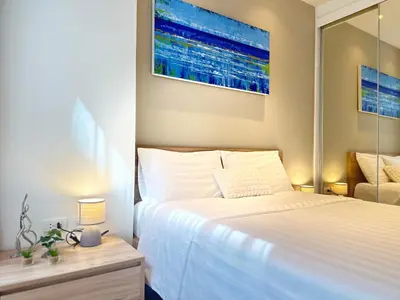 a bedroom with a white bed and a mirror at Diamond Phuket Bang Tao in Bang Tao Beach