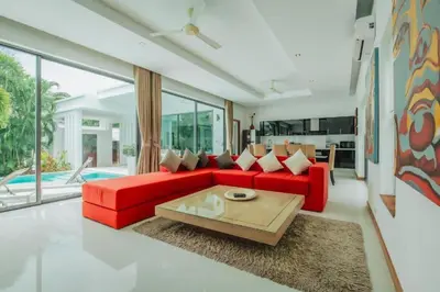a living room with a red couch and a table at Zen Private Pool Villa Little Paradise in Rawai Beach