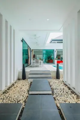 a hallway of a house with a pathway of rocks at Zen Private Pool Villa Little Paradise in Rawai Beach