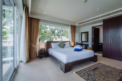 a bedroom with a bed and a large window at Daisy 2 Bedroom Amazing Seaview in Rawai Beach