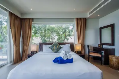 a bedroom with a white bed with a desk and a window at Daisy 2 Bedroom Amazing Seaview in Rawai Beach