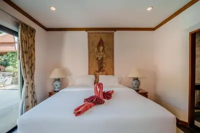 a bedroom with a white bed with a bow on it at Solas Pool Villa Grand Villa With Private Pool in Rawai Beach