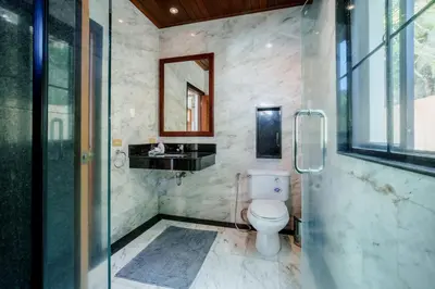 a bathroom with a toilet and a glass shower at Solas Pool Villa Grand Villa With Private Pool in Rawai Beach