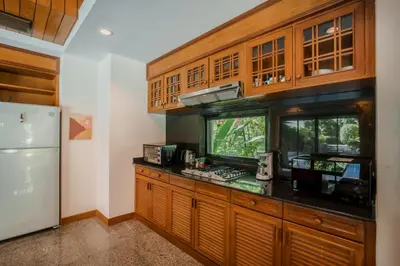 a kitchen with wooden cabinets and a counter top at Solas Pool Villa Grand Villa With Private Pool in Rawai Beach