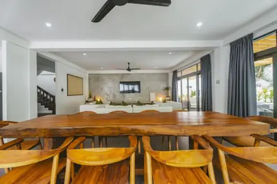 a dining room with a wooden table and chairs at Eden Villa A Tropical Paradise Pool Villa in Rawai Beach