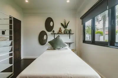 a bedroom with a large bed and a window at Eden Villa A Tropical Paradise Pool Villa in Rawai Beach