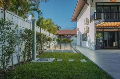 a courtyard of a house with a grass yard at Eden Villa A Tropical Paradise Pool Villa in Rawai Beach