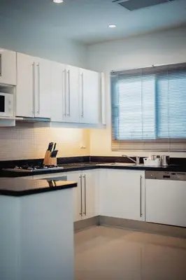 a white kitchen with white cabinets and a window at Ivory Pool Villa Dreamy Villa With Sparkling Pool in Rawai Beach