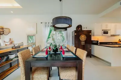 a dining room with a table and chairs and a kitchen at Ivory Pool Villa Dreamy Villa With Sparkling Pool in Rawai Beach
