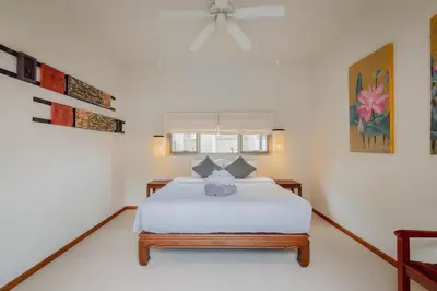 a bedroom with a white bed and a ceiling fan at Ivory Pool Villa Dreamy Villa With Sparkling Pool in Rawai Beach