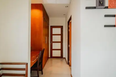 a hallway with a wooden door and a stair case at Ivory Pool Villa Dreamy Villa With Sparkling Pool in Rawai Beach