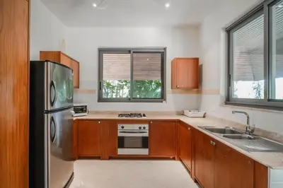 a kitchen with wooden cabinets and a stainless steel refrigerator at Orchid Pool Villa Lavish Villa In Perfect Location in Rawai Beach