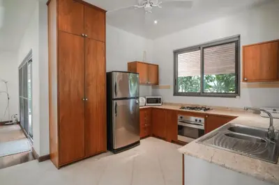 a kitchen with a stainless steel refrigerator and wooden cabinets at Orchid Pool Villa Lavish Villa In Perfect Location in Rawai Beach