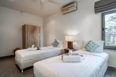 two beds in a room with white walls and a window at Orchid Pool Villa Lavish Villa In Perfect Location in Rawai Beach