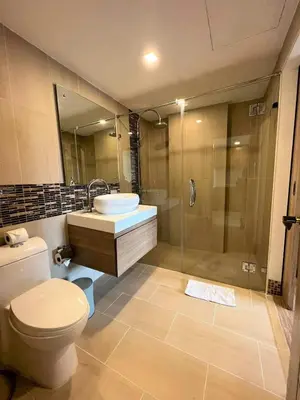 a bathroom with a toilet and a sink and a shower at Calypso Gardens 1 Bedroom Condo In Nai Harn in Rawai Beach