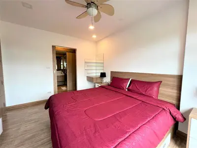 a bedroom with a large pink bed with a ceiling fan at Calypso Gardens 1 Bedroom Condo In Nai Harn in Rawai Beach