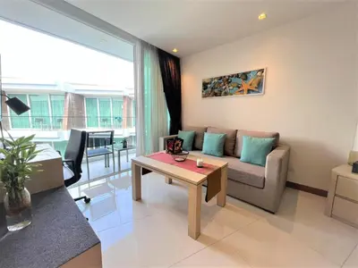 a living room with a couch and a table at Maroon Studio at the beachfront in Rawai Beach