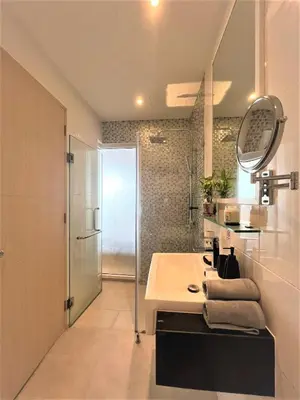 a bathroom with a sink and a mirror and a shower at Maroon Studio at the beachfront in Rawai Beach