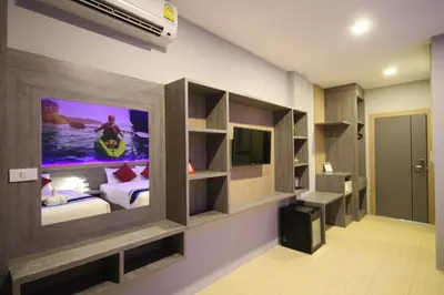 a bedroom with a tv on the wall and a bed at KRABI Residence in Ban Khlong Haeng
