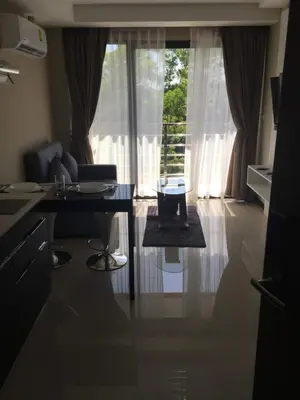 a living room with a table and a window at Mai Khao Beach Apartments in Mai Khao Beach