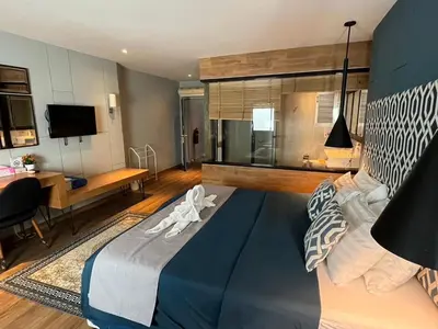 a bedroom with a large blue bed and a desk at Fantastic Karon Beach guest house in Karon Beach