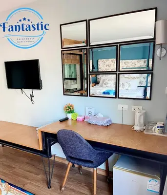 a desk with a blue chair and a tv at Fantastic Karon Beach guest house in Karon Beach