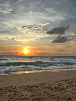 a sunset on a beach with the ocean at Fantastic Karon Beach guest house in Karon Beach