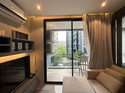a living room with a couch and a large window at Luxury one apartment for rent Kamala in Kathu