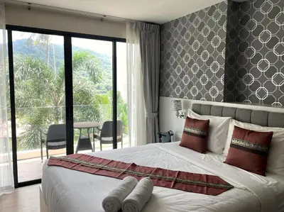 a bedroom with a large bed with a large window at Cozy studio Splendid Condo by Lofty in Kata Beach