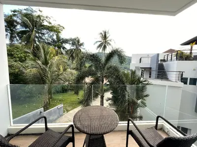 a balcony with a table and chairs and palm trees at Cozy studio Splendid Condo by Lofty in Kata Beach