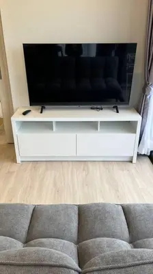 a living room with a couch and a flat screen tv at Laguna Sky Park Corner 1 Bedroom in Bang Tao Beach