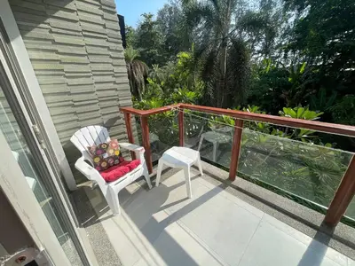 a balcony with two chairs and a table on a balcony at Naithon beach WERT in Phuket Town